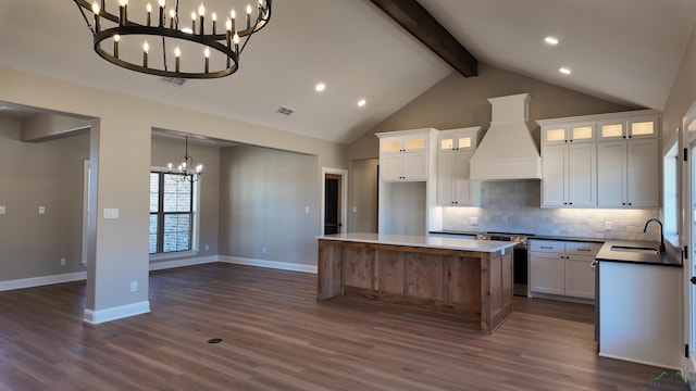 kitchen with backsplash, an inviting chandelier, a sink, premium range hood, and beamed ceiling