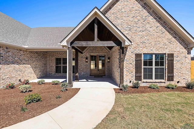 169 Andres Ln, Kilgore, TX 75662 - entrance to property featuring french doors, brick siding, and a lawn