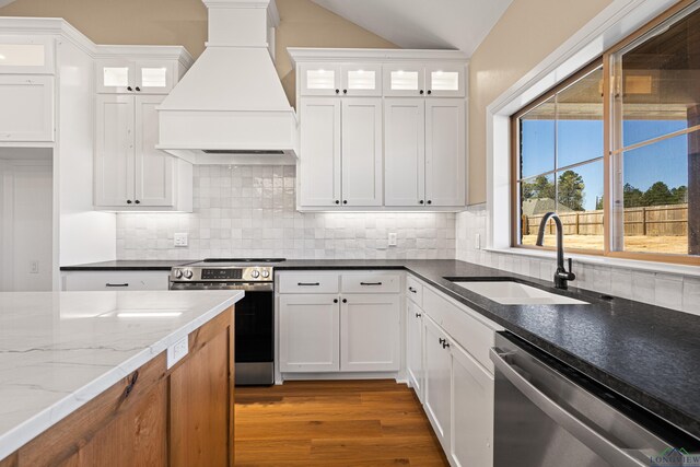 169 Andres Ln, Kilgore, TX 75662 - kitchen with custom range hood, white cabinets, a sink, and stainless steel appliances