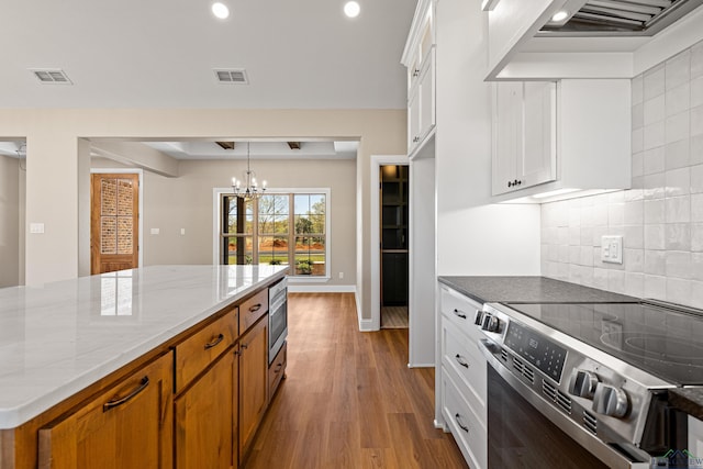 169 Andres Ln, Kilgore, TX 75662 - kitchen with visible vents, light stone counters, a chandelier, and electric range oven