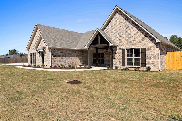169 Andres Ln, Kilgore, TX 75662 - view of front of home with brick siding, fence, a front lawn, and roof with shingles