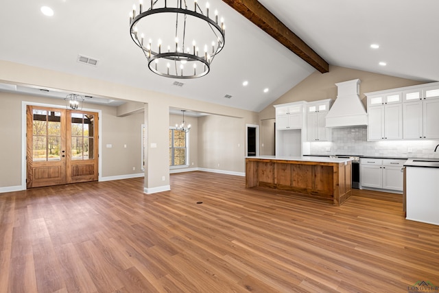 169 Andres Ln, Kilgore, TX 75662 - kitchen featuring decorative backsplash, visible vents, premium range hood, open floor plan, and an inviting chandelier
