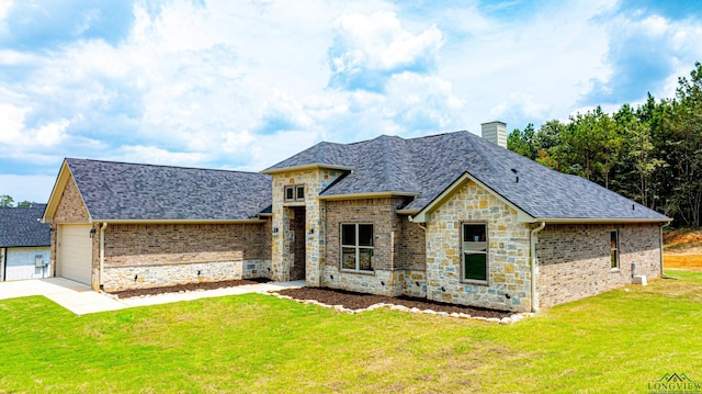 view of front of property featuring a garage and a front lawn