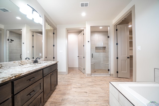 bathroom featuring vanity, hardwood / wood-style flooring, and separate shower and tub