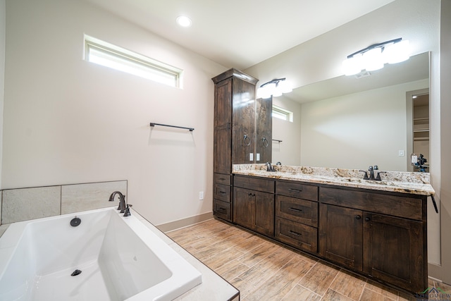 bathroom with plenty of natural light, vanity, and a bath