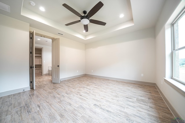 spare room featuring a tray ceiling and ceiling fan