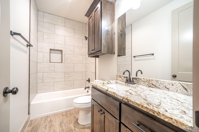 full bathroom with hardwood / wood-style flooring, vanity, toilet, and tiled shower / bath