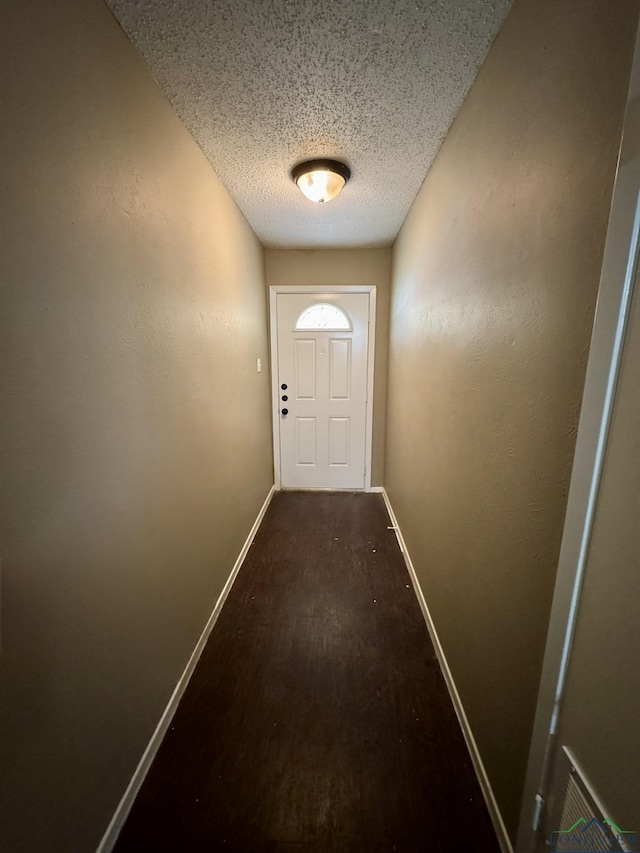 entryway featuring baseboards and a textured ceiling