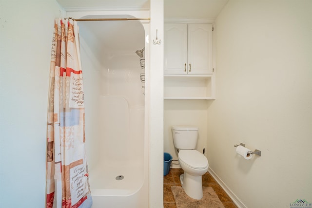 bathroom featuring toilet and walk in shower