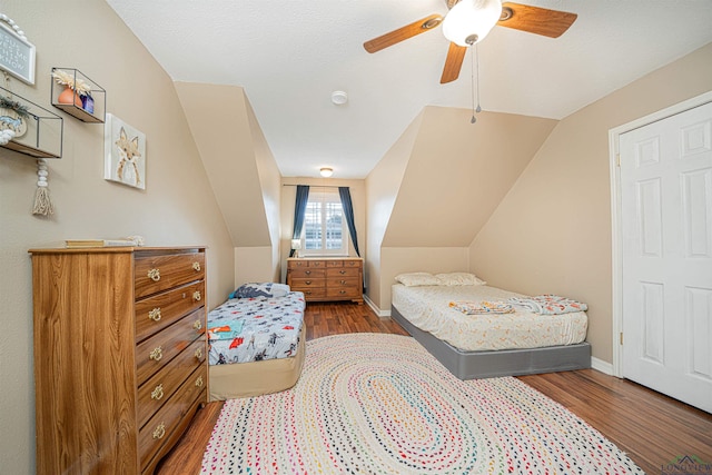 bedroom featuring ceiling fan, lofted ceiling, and hardwood / wood-style floors