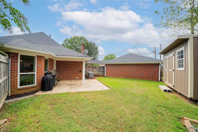 view of yard featuring central air condition unit, a shed, and a patio area