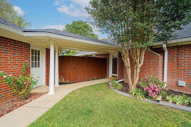 entrance to property with a lawn