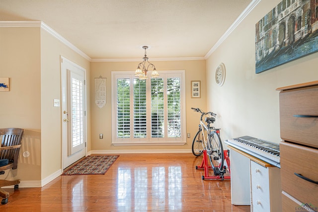 interior space with light wood-type flooring, a notable chandelier, and ornamental molding