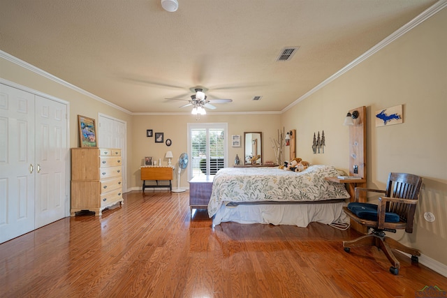 bedroom featuring ceiling fan, wood-type flooring, crown molding, and a textured ceiling