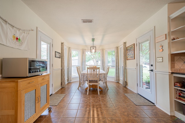 tiled dining space with a textured ceiling