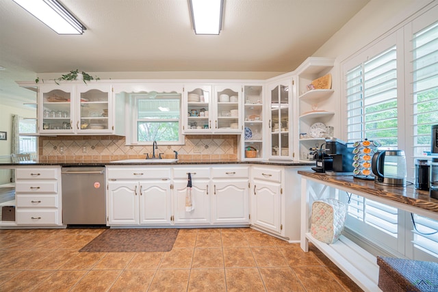 kitchen featuring light tile patterned flooring, white cabinets, tasteful backsplash, and sink