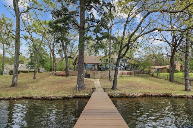 view of dock with a water view and a yard