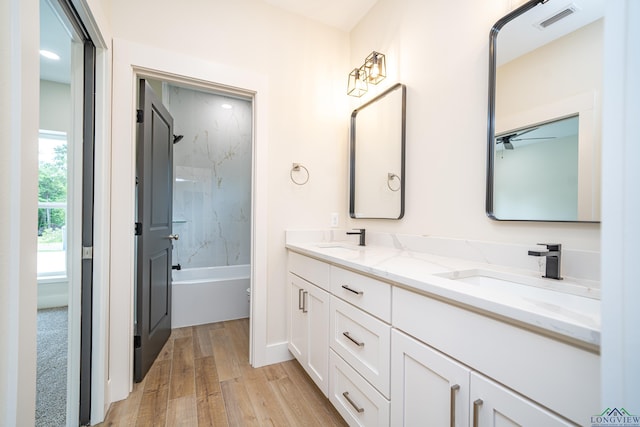 bathroom with vanity, wood-type flooring, and washtub / shower combination