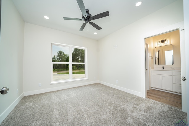 unfurnished bedroom featuring ensuite bath, ceiling fan, sink, and carpet floors