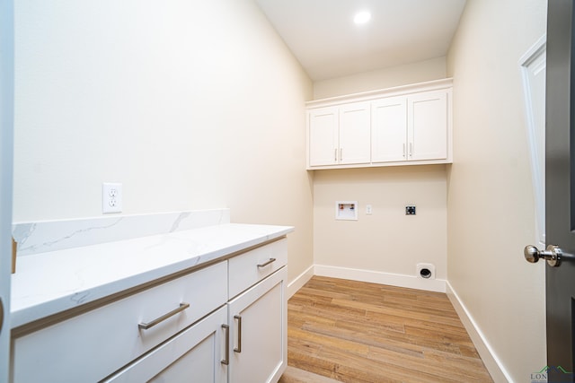 laundry room featuring hookup for an electric dryer, washer hookup, light hardwood / wood-style flooring, and cabinets