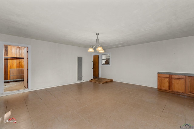 unfurnished room with a notable chandelier