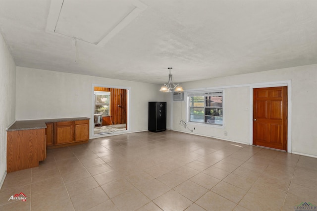 unfurnished room with light tile patterned floors and a notable chandelier