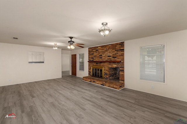 unfurnished living room featuring ceiling fan, a fireplace, and hardwood / wood-style floors