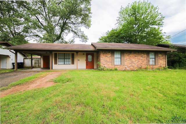single story home with an attached carport, brick siding, a front yard, and aphalt driveway