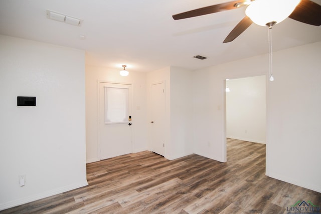 empty room featuring baseboards, a ceiling fan, wood finished floors, and visible vents