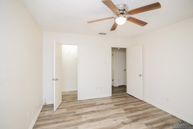 unfurnished bedroom featuring baseboards, visible vents, and light wood-style floors