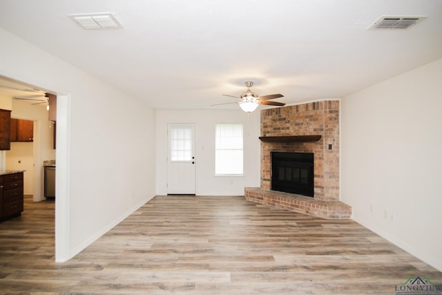 unfurnished living room with visible vents, a ceiling fan, and wood finished floors