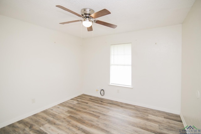 spare room with baseboards, a ceiling fan, and wood finished floors