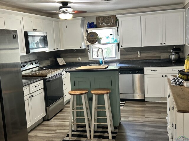 kitchen featuring tasteful backsplash, white cabinetry, sink, and stainless steel appliances