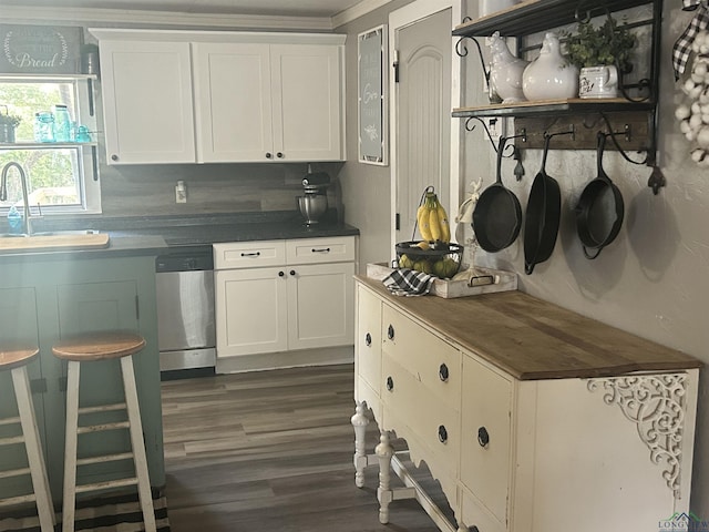 kitchen with tasteful backsplash, white cabinetry, sink, and stainless steel dishwasher