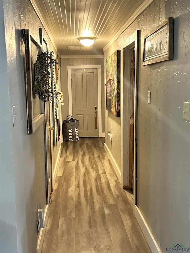 hall featuring hardwood / wood-style flooring, wooden ceiling, and crown molding