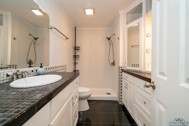 bathroom featuring vanity, tile patterned floors, toilet, ornamental molding, and tiled shower