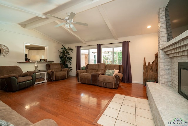 living room featuring a fireplace, lofted ceiling with beams, light hardwood / wood-style floors, and ceiling fan