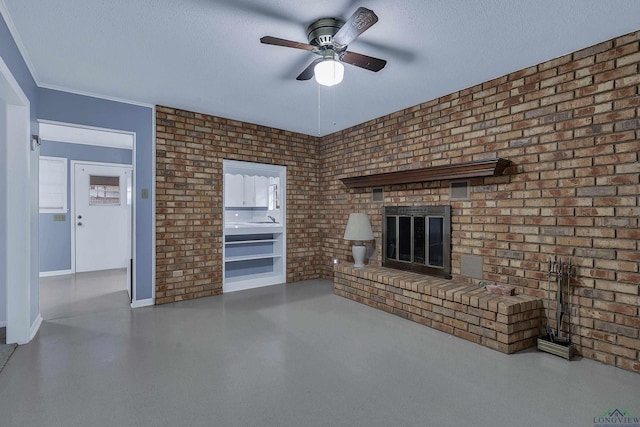 unfurnished living room featuring a brick fireplace, ceiling fan, a textured ceiling, and brick wall