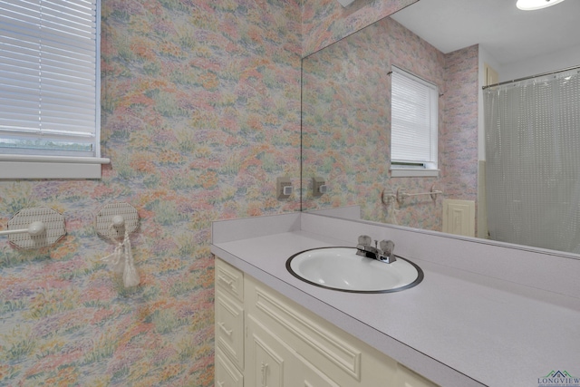 full bathroom featuring vanity and wallpapered walls