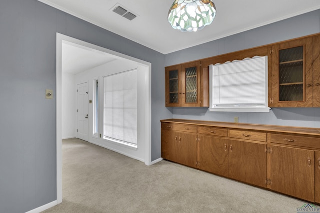 kitchen with brown cabinets, light colored carpet, visible vents, and glass insert cabinets