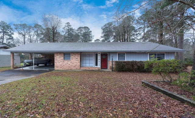 single story home featuring a carport, brick siding, and driveway