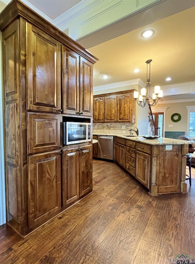 kitchen featuring backsplash, an inviting chandelier, a kitchen breakfast bar, hanging light fixtures, and stainless steel appliances