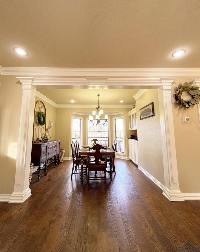 dining space featuring dark wood-type flooring, a notable chandelier, and ornamental molding