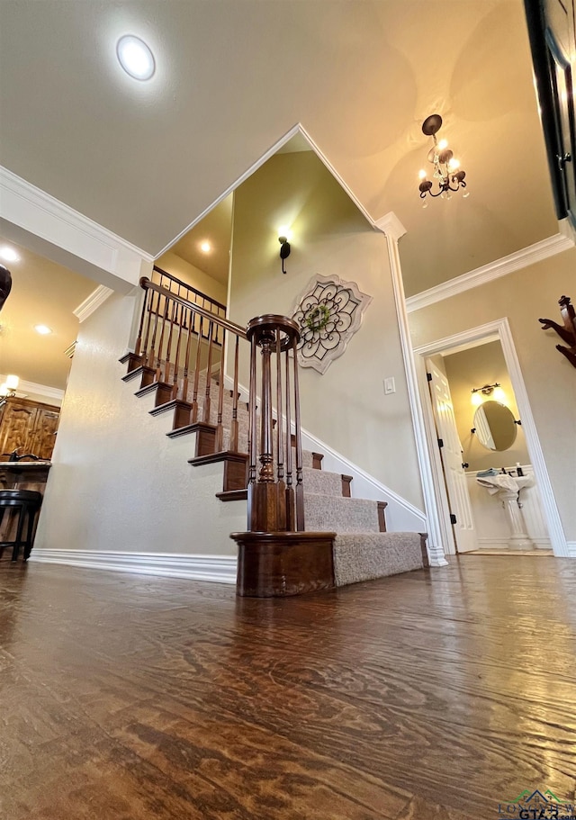 staircase with ornamental molding and an inviting chandelier