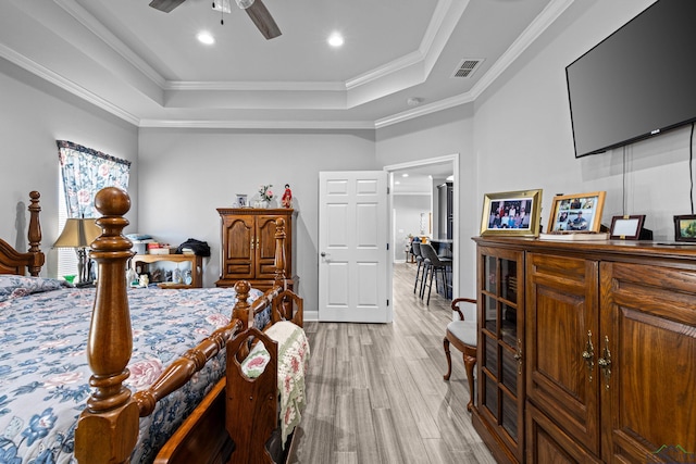 bedroom with crown molding, ceiling fan, a raised ceiling, and light hardwood / wood-style flooring