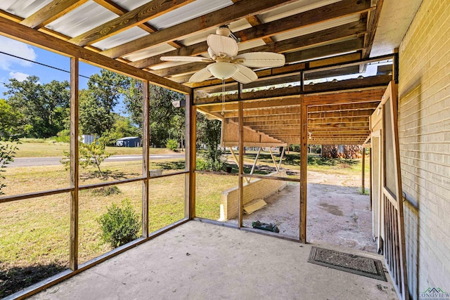 unfurnished sunroom with ceiling fan