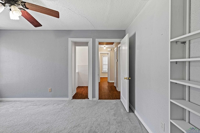 unfurnished bedroom with ceiling fan, carpet floors, and a textured ceiling