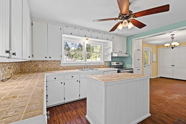 kitchen featuring electric range, white cabinets, dark wood-type flooring, and a kitchen island