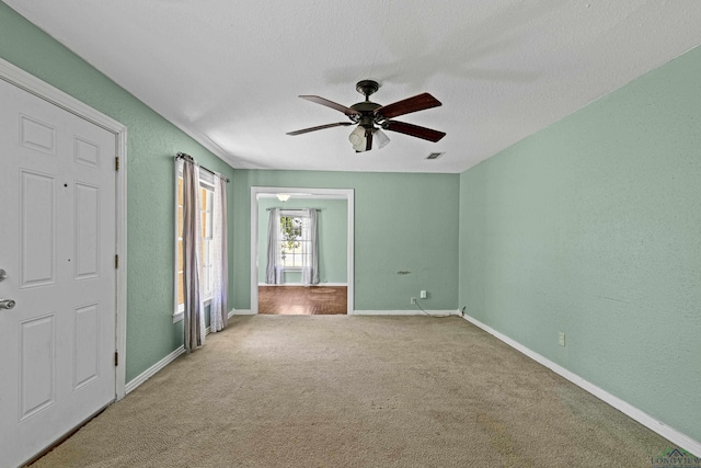 carpeted spare room with ceiling fan and a textured ceiling