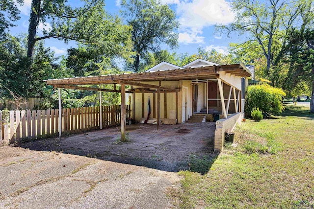 view of front of house with a carport and a front lawn